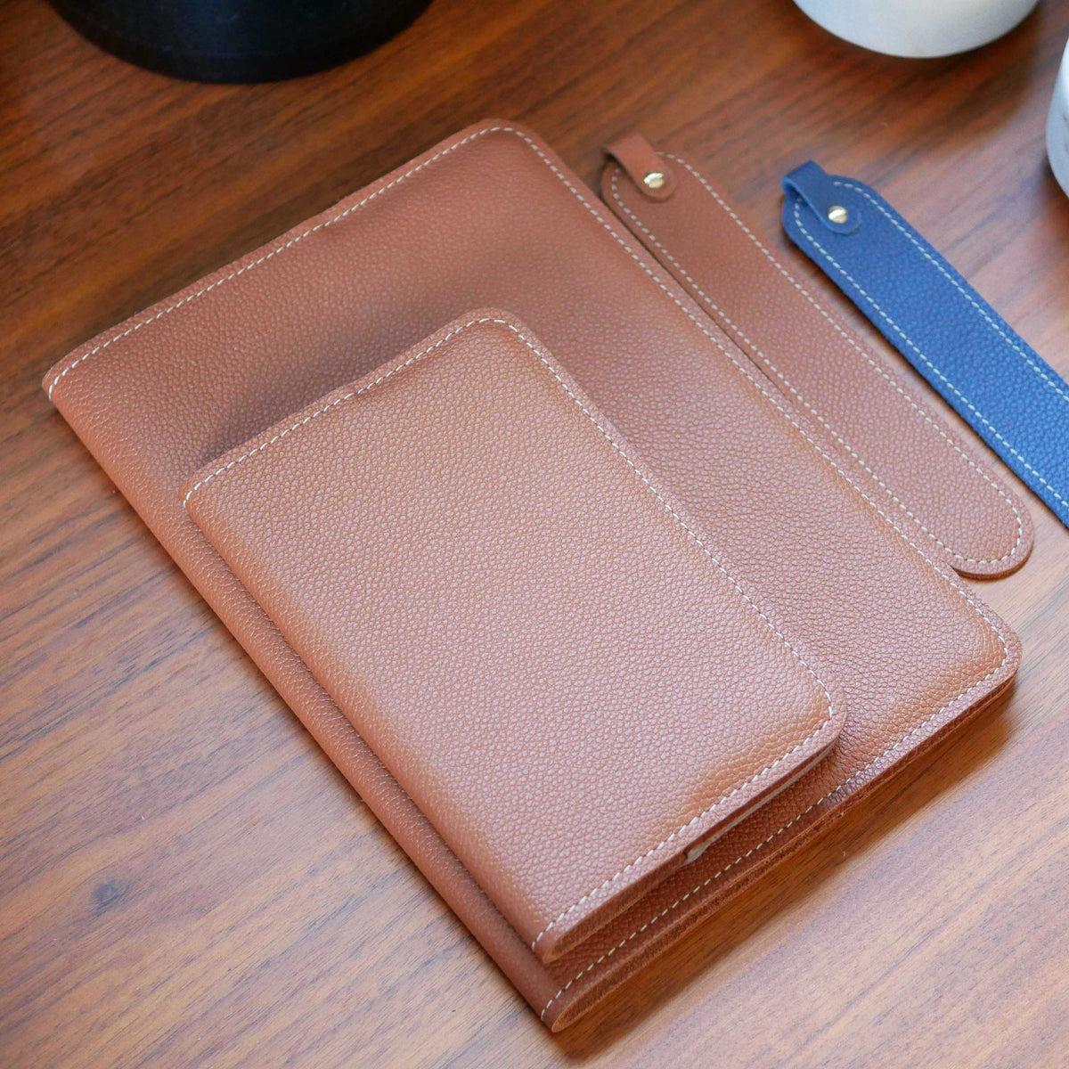 Petit et grand protège-carnet A4 en cuir camel, marque page bleu, personnalisables, fabriqués dans mon atelier en Bretagne